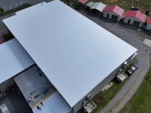 Commercial metal roof restored with Uniflex spray coating system, providing long-lasting waterproof protection, energy efficiency, and corrosion resistance for an industrial building.