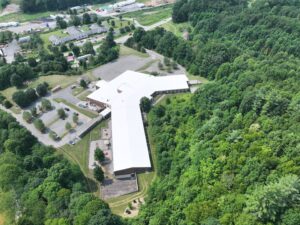 Wide aerial image of Freedom Trail School in Newland, NC featuring a professionally installed white TPO roofing system covering the entire educational facility.