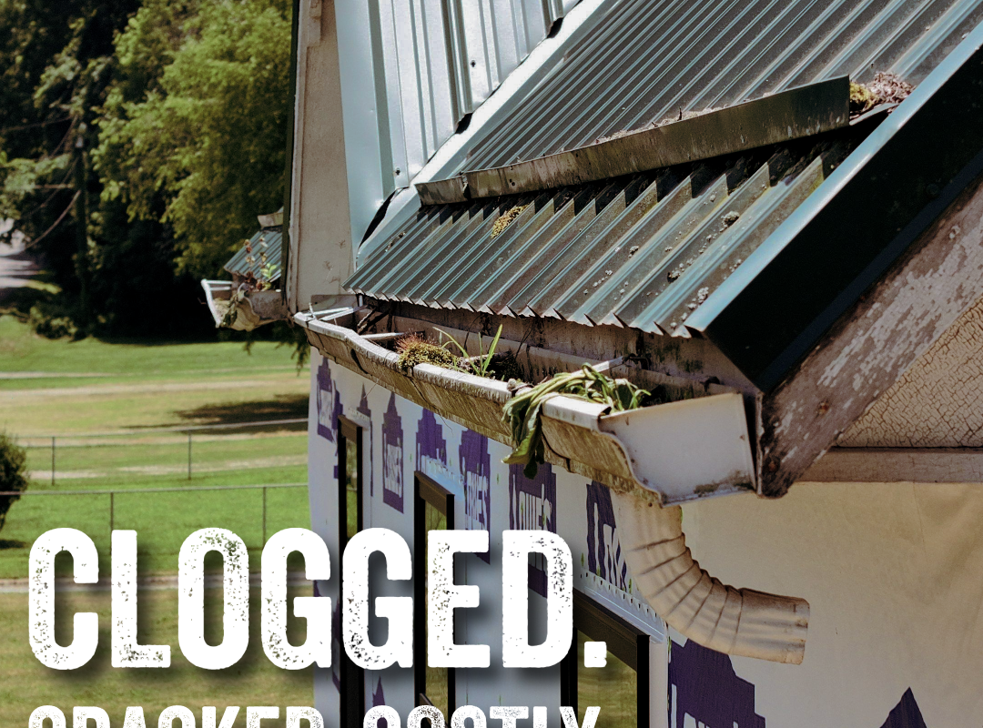 Clogged rain gutter filled with leaves and debris beneath a metal roof, highlighting the importance of fall gutter maintenance before winter.